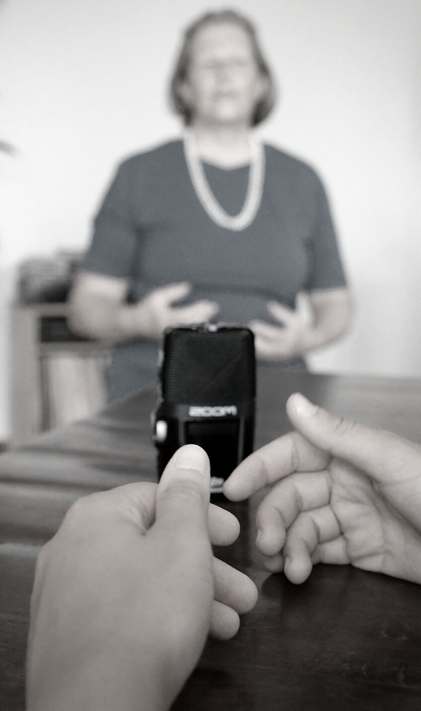 a blurred person sits behind a sound recorder