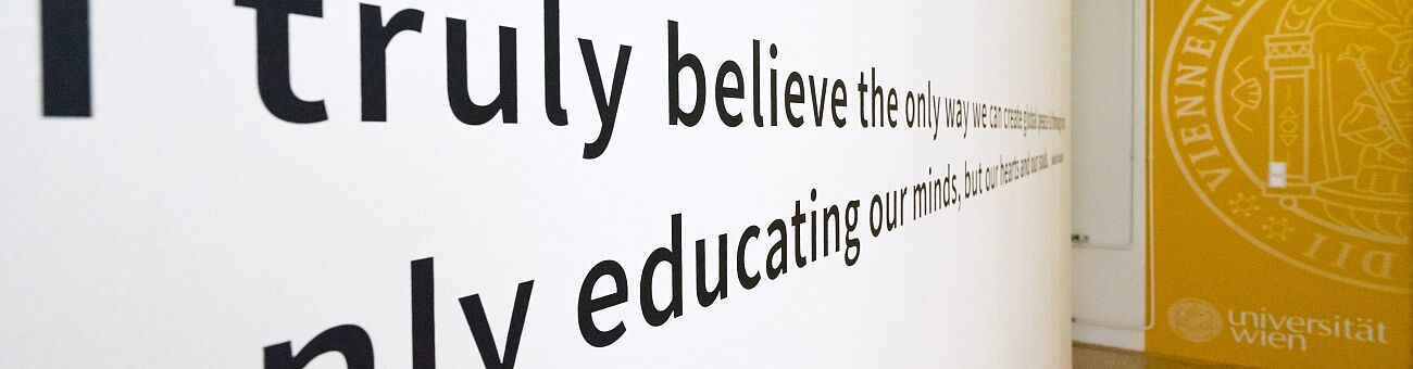 a hallway at the Center for Teacher Education with a long quote on the wall; foregrounded are the letters 