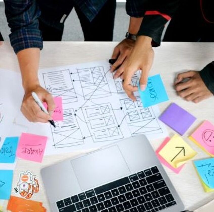 a laptop on a table with lots of colorful post-its