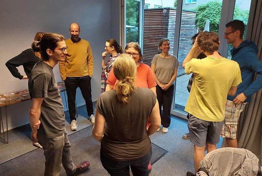 die Team-Mitglieder stehen in Gruppen und reden miteinander